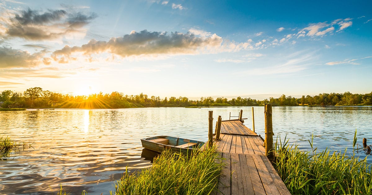 Calm lake with dock and sunset